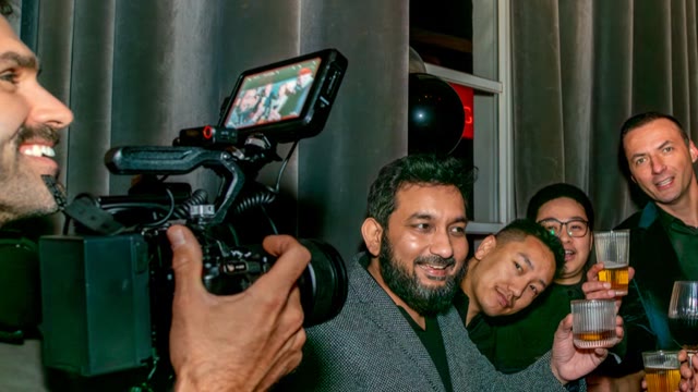 A camera operator films a group of colleagues at a Christmas party