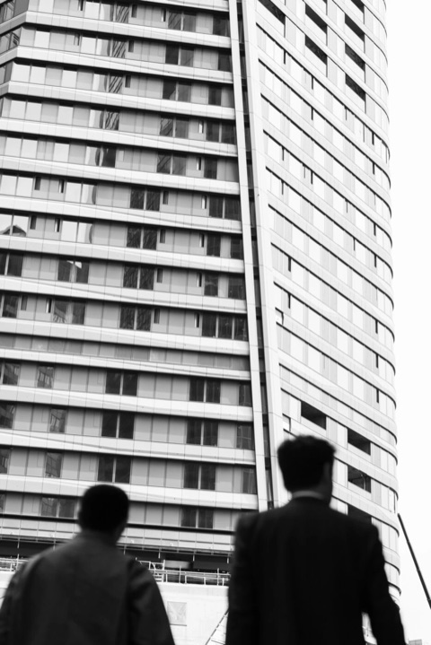 Schwarzweißfoto: zwei Silhouetten vor einem Hochhaus