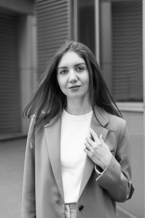 Schwarzweißporträt einer Frau im Blazer, der Wind im Haar