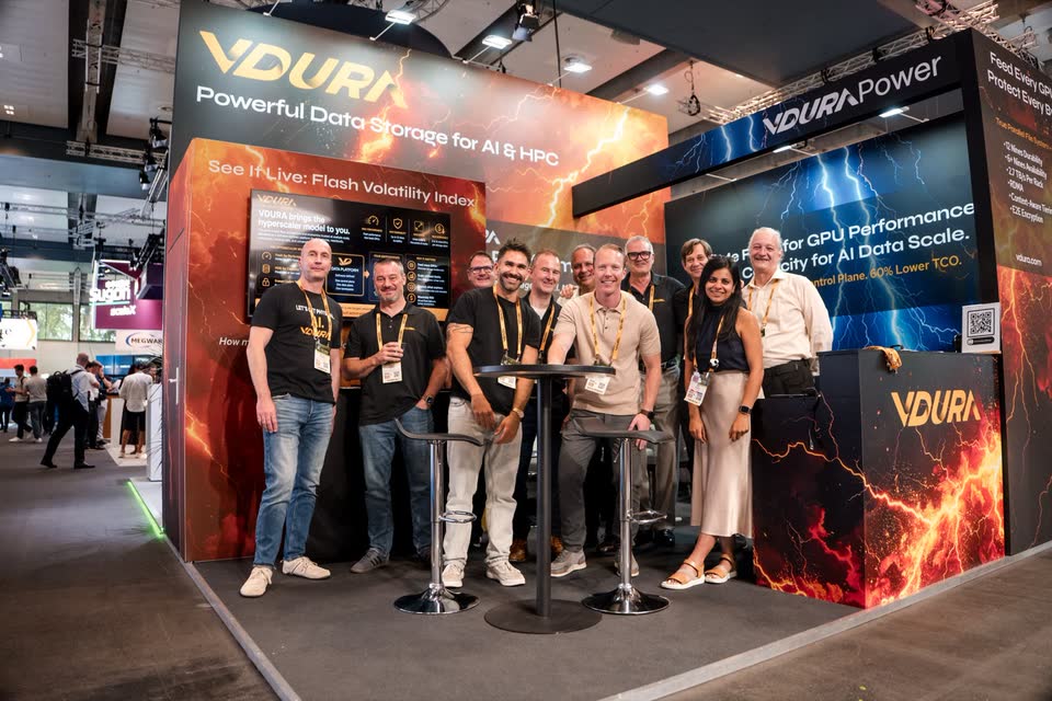 Das Standteam von VDURA in schwarzen T-Shirts vor dem eigenen Messestand